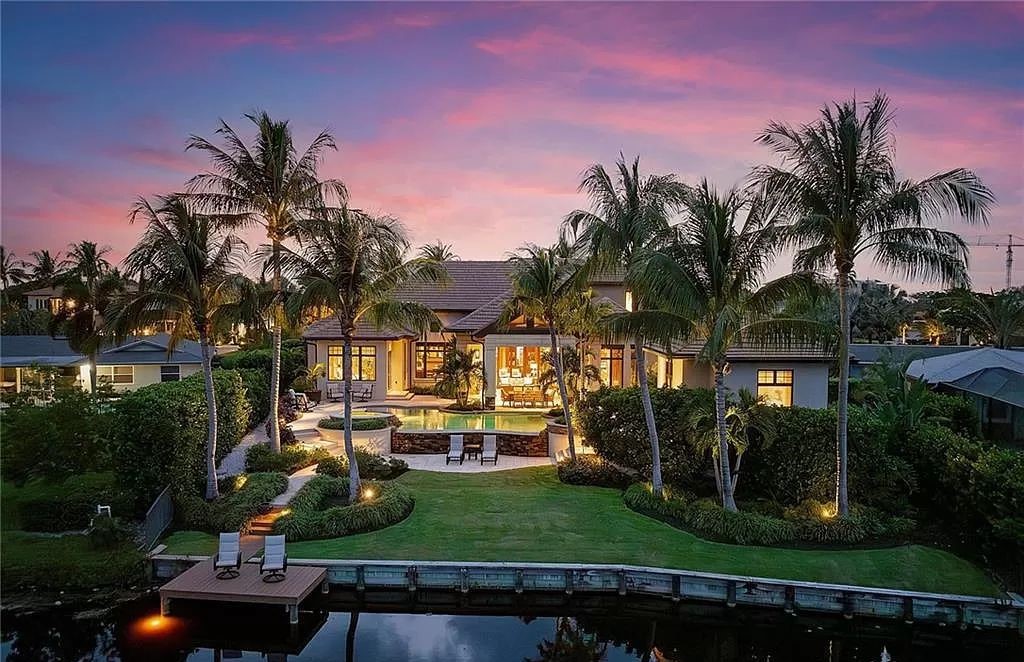 Discover the epitome of luxury living in the heart of Naples at 655 Bougainvillea Rd. This exquisite 7,660-square-foot lakefront estate, crafted by renowned architect John Cooney, boasts a seamless blend of warm tones and minimalist design.