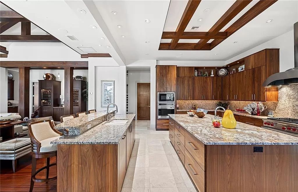 Discover the epitome of luxury living in the heart of Naples at 655 Bougainvillea Rd. This exquisite 7,660-square-foot lakefront estate, crafted by renowned architect John Cooney, boasts a seamless blend of warm tones and minimalist design.