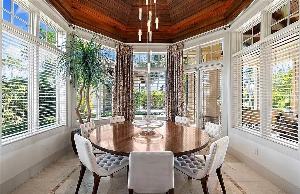 Discover the epitome of luxury living in the heart of Naples at 655 Bougainvillea Rd. This exquisite 7,660-square-foot lakefront estate, crafted by renowned architect John Cooney, boasts a seamless blend of warm tones and minimalist design.