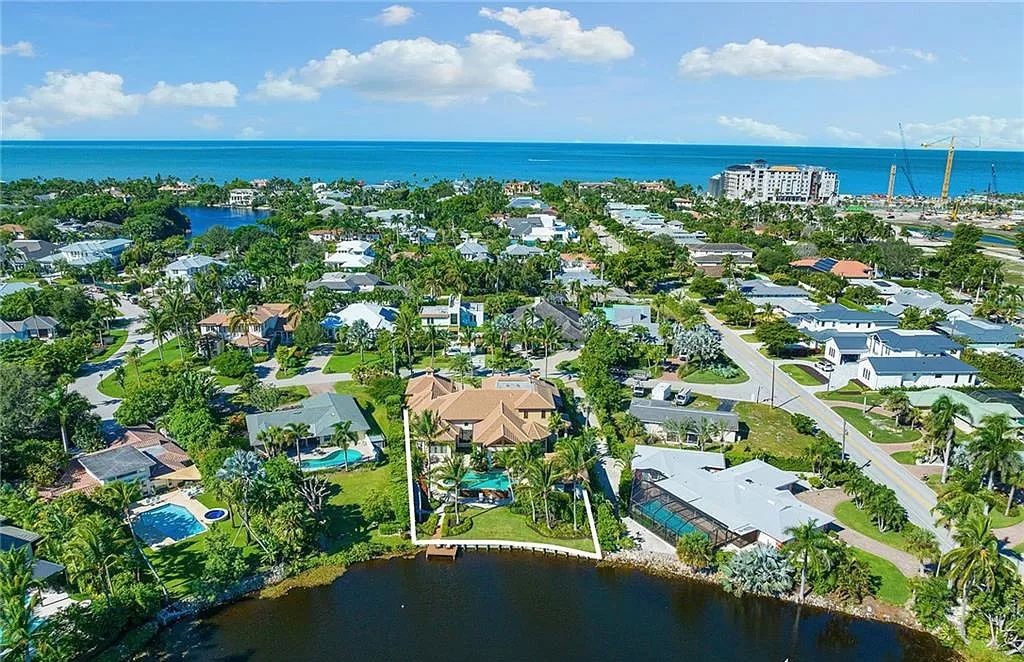 Discover the epitome of luxury living in the heart of Naples at 655 Bougainvillea Rd. This exquisite 7,660-square-foot lakefront estate, crafted by renowned architect John Cooney, boasts a seamless blend of warm tones and minimalist design.