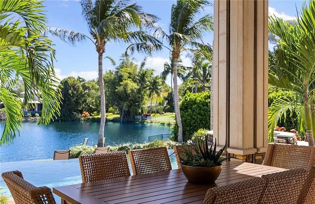 Discover the epitome of luxury living in the heart of Naples at 655 Bougainvillea Rd. This exquisite 7,660-square-foot lakefront estate, crafted by renowned architect John Cooney, boasts a seamless blend of warm tones and minimalist design.