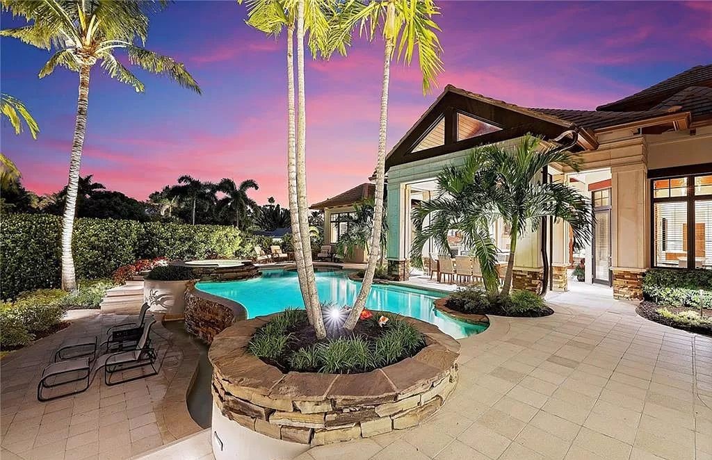 Discover the epitome of luxury living in the heart of Naples at 655 Bougainvillea Rd. This exquisite 7,660-square-foot lakefront estate, crafted by renowned architect John Cooney, boasts a seamless blend of warm tones and minimalist design.