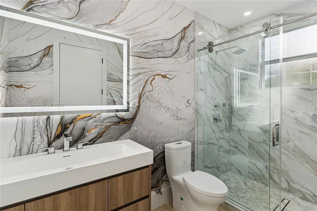 Welcome to the epitome of contemporary luxury living in Pinecrest! This striking newly constructed family compound offers a seamless blend of timeless transitional style and modern functionality. Spanning 7,778 square feet on a lush 0.89-acre lot, this masterpiece features two separate family quarters with flexible spaces, ideal for multi-generational living or personalized workspaces.