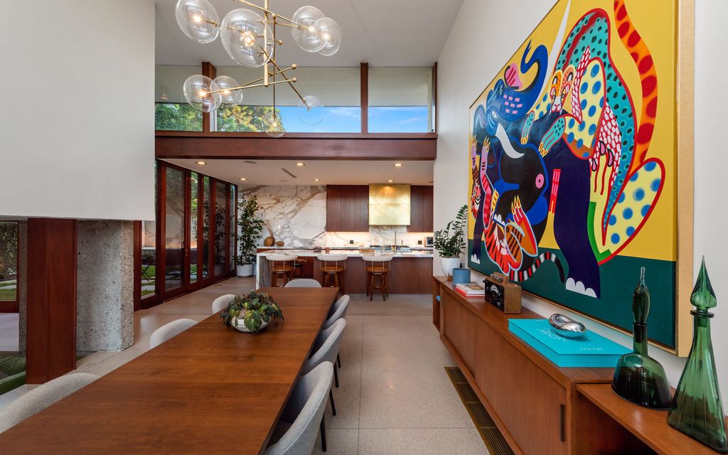 1875 Carla Ridge Home in Beverly Hills, California. Behold an architectural masterpiece designed by Rex Lotery in 1965—a stunning Mid-Century home crafted with concrete, wood, glass, and stone. This rare gem stands out as one of only a handful of two-story homes in the coveted Trousdale neighborhood, and it has recently undergone a meticulous renovation to enhance its timeless allure.