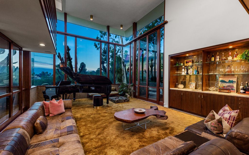 1875 Carla Ridge Home in Beverly Hills, California. Behold an architectural masterpiece designed by Rex Lotery in 1965—a stunning Mid-Century home crafted with concrete, wood, glass, and stone. This rare gem stands out as one of only a handful of two-story homes in the coveted Trousdale neighborhood, and it has recently undergone a meticulous renovation to enhance its timeless allure.