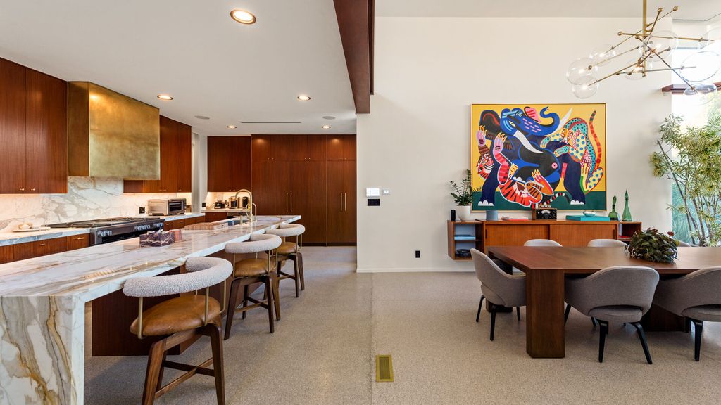 1875 Carla Ridge Home in Beverly Hills, California. Behold an architectural masterpiece designed by Rex Lotery in 1965—a stunning Mid-Century home crafted with concrete, wood, glass, and stone. This rare gem stands out as one of only a handful of two-story homes in the coveted Trousdale neighborhood, and it has recently undergone a meticulous renovation to enhance its timeless allure.