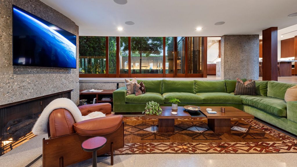 1875 Carla Ridge Home in Beverly Hills, California. Behold an architectural masterpiece designed by Rex Lotery in 1965—a stunning Mid-Century home crafted with concrete, wood, glass, and stone. This rare gem stands out as one of only a handful of two-story homes in the coveted Trousdale neighborhood, and it has recently undergone a meticulous renovation to enhance its timeless allure.