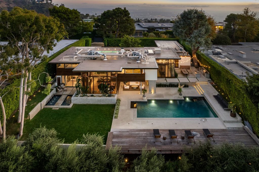 1875 Carla Ridge Home in Beverly Hills, California. Behold an architectural masterpiece designed by Rex Lotery in 1965—a stunning Mid-Century home crafted with concrete, wood, glass, and stone. This rare gem stands out as one of only a handful of two-story homes in the coveted Trousdale neighborhood, and it has recently undergone a meticulous renovation to enhance its timeless allure.