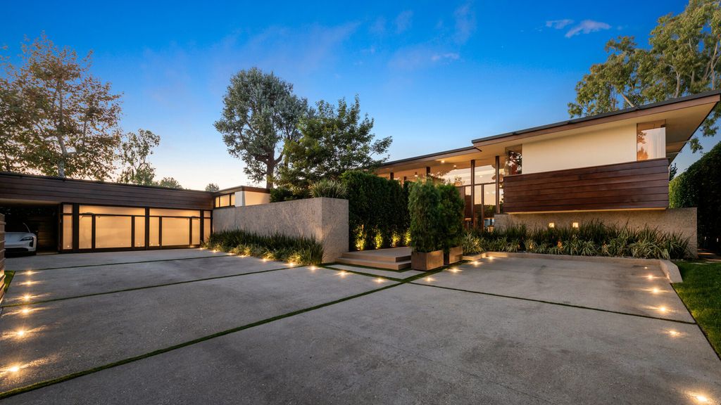 1875 Carla Ridge Home in Beverly Hills, California. Behold an architectural masterpiece designed by Rex Lotery in 1965—a stunning Mid-Century home crafted with concrete, wood, glass, and stone. This rare gem stands out as one of only a handful of two-story homes in the coveted Trousdale neighborhood, and it has recently undergone a meticulous renovation to enhance its timeless allure.