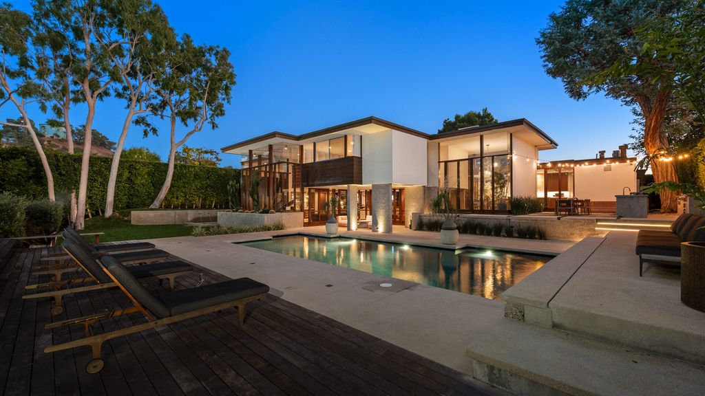 1875 Carla Ridge Home in Beverly Hills, California. Behold an architectural masterpiece designed by Rex Lotery in 1965—a stunning Mid-Century home crafted with concrete, wood, glass, and stone. This rare gem stands out as one of only a handful of two-story homes in the coveted Trousdale neighborhood, and it has recently undergone a meticulous renovation to enhance its timeless allure.