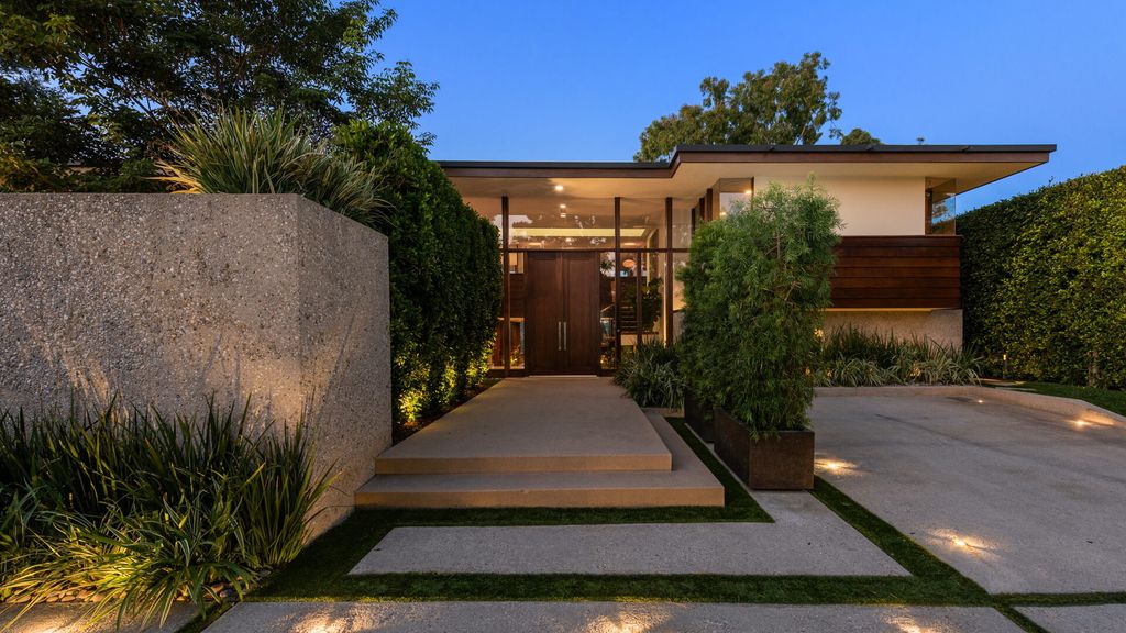 1875 Carla Ridge Home in Beverly Hills, California. Behold an architectural masterpiece designed by Rex Lotery in 1965—a stunning Mid-Century home crafted with concrete, wood, glass, and stone. This rare gem stands out as one of only a handful of two-story homes in the coveted Trousdale neighborhood, and it has recently undergone a meticulous renovation to enhance its timeless allure.
