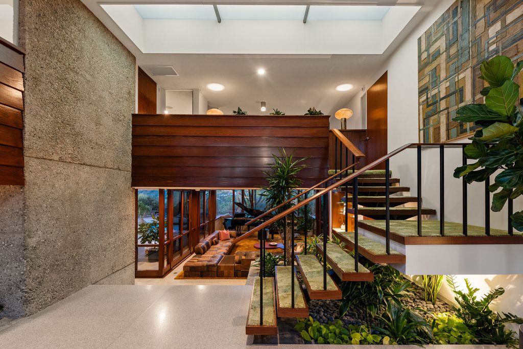 1875 Carla Ridge Home in Beverly Hills, California. Behold an architectural masterpiece designed by Rex Lotery in 1965—a stunning Mid-Century home crafted with concrete, wood, glass, and stone. This rare gem stands out as one of only a handful of two-story homes in the coveted Trousdale neighborhood, and it has recently undergone a meticulous renovation to enhance its timeless allure.