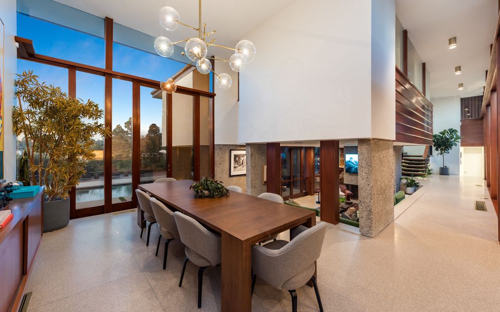 1875 Carla Ridge Home in Beverly Hills, California. Behold an architectural masterpiece designed by Rex Lotery in 1965—a stunning Mid-Century home crafted with concrete, wood, glass, and stone. This rare gem stands out as one of only a handful of two-story homes in the coveted Trousdale neighborhood, and it has recently undergone a meticulous renovation to enhance its timeless allure.