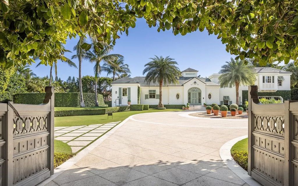 Nestled in Palm Beach's prestigious Estate Section, this 1.3+/- acre property epitomizes luxury living with a stunning clay tennis court, two guest houses, and immaculate grounds. A gated entry leads to a circular drive and ample parking, complemented by a separate service area and a 2-car garage.