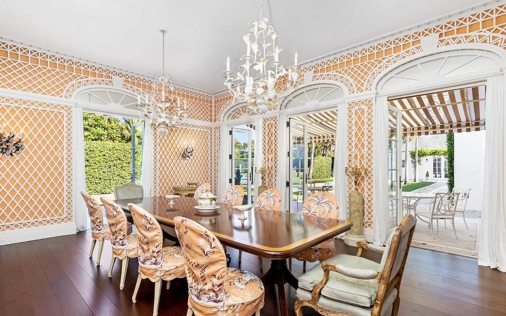Nestled in Palm Beach's prestigious Estate Section, this 1.3+/- acre property epitomizes luxury living with a stunning clay tennis court, two guest houses, and immaculate grounds. A gated entry leads to a circular drive and ample parking, complemented by a separate service area and a 2-car garage.