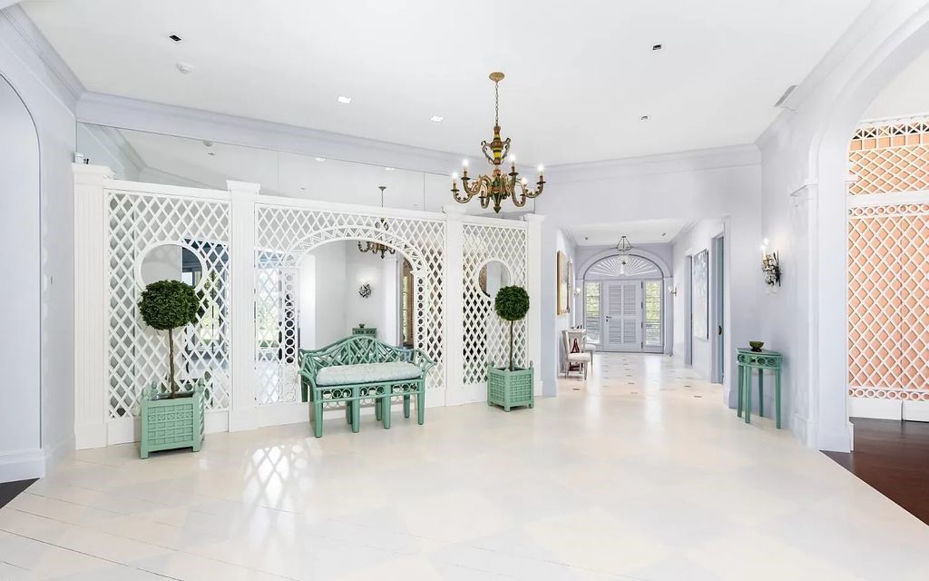 Nestled in Palm Beach's prestigious Estate Section, this 1.3+/- acre property epitomizes luxury living with a stunning clay tennis court, two guest houses, and immaculate grounds. A gated entry leads to a circular drive and ample parking, complemented by a separate service area and a 2-car garage.