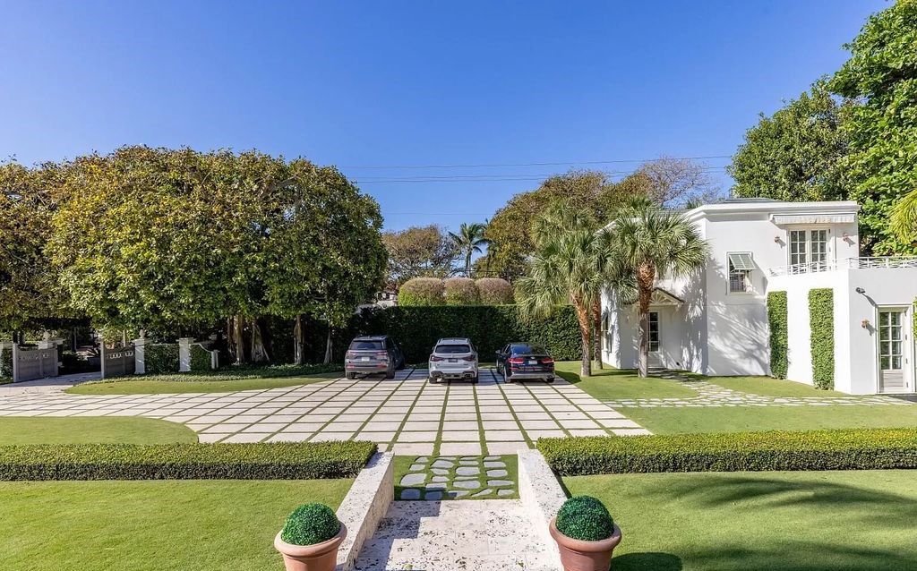 Nestled in Palm Beach's prestigious Estate Section, this 1.3+/- acre property epitomizes luxury living with a stunning clay tennis court, two guest houses, and immaculate grounds. A gated entry leads to a circular drive and ample parking, complemented by a separate service area and a 2-car garage.