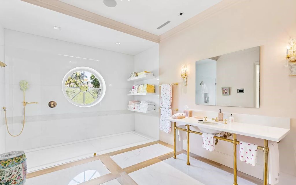 Nestled in Palm Beach's prestigious Estate Section, this 1.3+/- acre property epitomizes luxury living with a stunning clay tennis court, two guest houses, and immaculate grounds. A gated entry leads to a circular drive and ample parking, complemented by a separate service area and a 2-car garage.