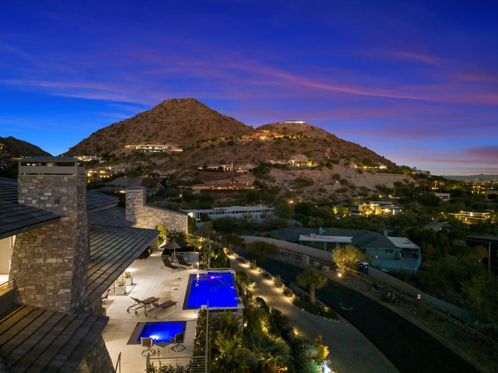 6850 North 39th Place Home in Paradise Valley, Arizona. Indulge in the epitome of luxury living with this exquisite hillside estate offering breathtaking city lights and Camelback Mountain views. Situated on just under 2.2 acres inside the guard-gated Paradise Reserve community, this newly crafted custom home seamlessly integrates indoor and outdoor spaces. 
