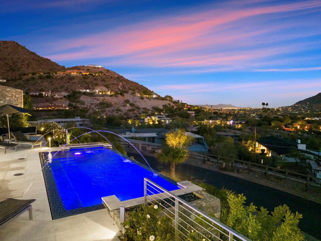 6850 North 39th Place Home in Paradise Valley, Arizona. Indulge in the epitome of luxury living with this exquisite hillside estate offering breathtaking city lights and Camelback Mountain views. Situated on just under 2.2 acres inside the guard-gated Paradise Reserve community, this newly crafted custom home seamlessly integrates indoor and outdoor spaces. 