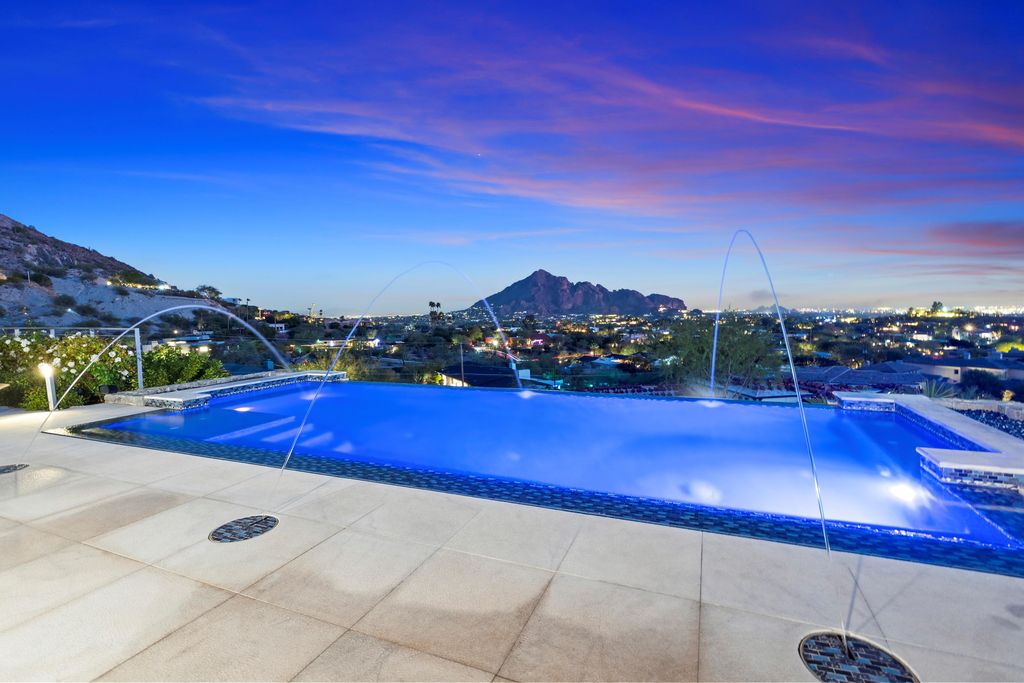 6850 North 39th Place Home in Paradise Valley, Arizona. Indulge in the epitome of luxury living with this exquisite hillside estate offering breathtaking city lights and Camelback Mountain views. Situated on just under 2.2 acres inside the guard-gated Paradise Reserve community, this newly crafted custom home seamlessly integrates indoor and outdoor spaces. 