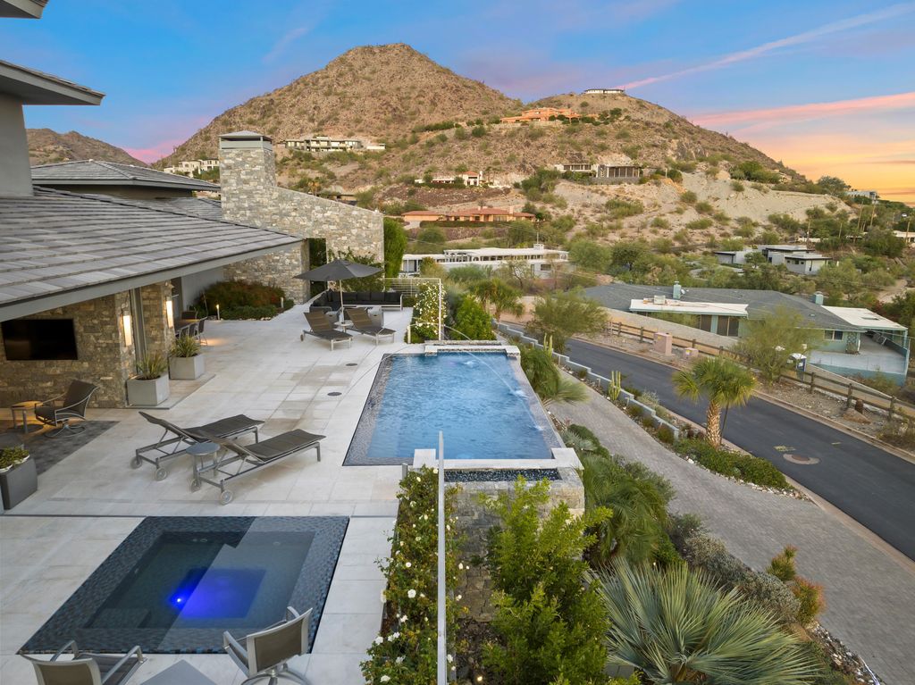 6850 North 39th Place Home in Paradise Valley, Arizona. Indulge in the epitome of luxury living with this exquisite hillside estate offering breathtaking city lights and Camelback Mountain views. Situated on just under 2.2 acres inside the guard-gated Paradise Reserve community, this newly crafted custom home seamlessly integrates indoor and outdoor spaces. 