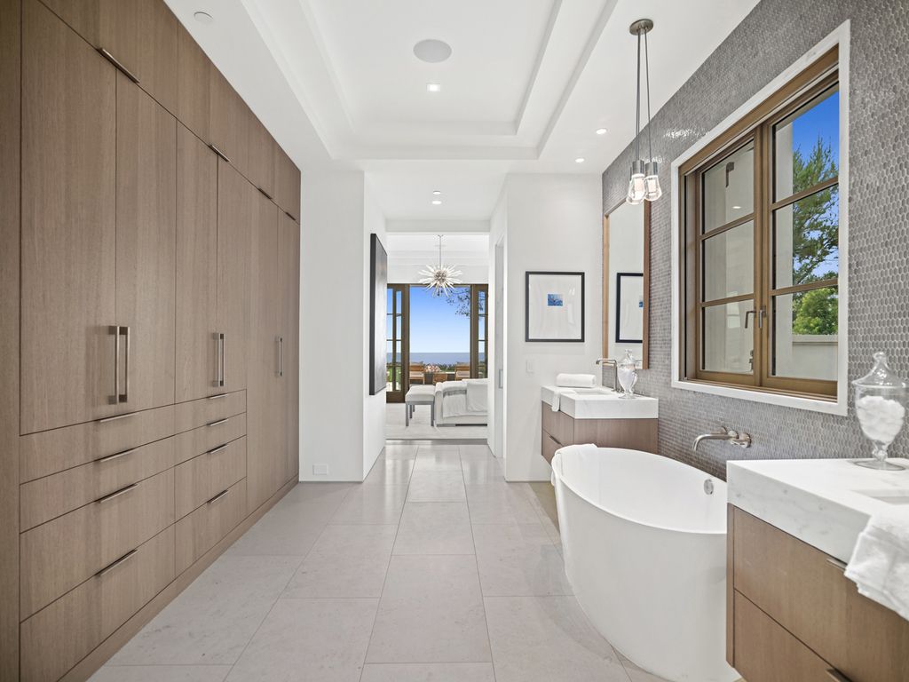 21 Spinnaker Home in Newport Coast, California. Discover luxury living at its finest in this stunning 11,700 sq. ft. estate in Crystal Cove. Completed in 2020, this meticulously designed residence offers unobstructed ocean and coastline views, dual master suites, a chef's kitchen, home theater, gym, and more. 