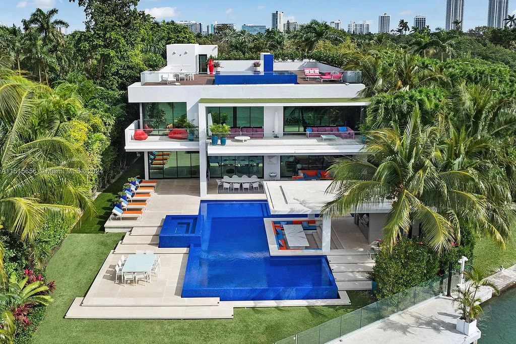 Welcome to 5004 N Bay Rd, a 2016 masterpiece by renowned designer Jennifer Post, blending modern architecture with timeless elegance. This 8-bed, 9-bath waterfront haven on prestigious North Bay Road boasts a stunning atrium courtyard, seamless living spaces, and a gourmet kitchen.