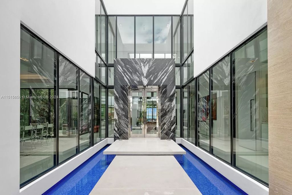 Welcome to 5004 N Bay Rd, a 2016 masterpiece by renowned designer Jennifer Post, blending modern architecture with timeless elegance. This 8-bed, 9-bath waterfront haven on prestigious North Bay Road boasts a stunning atrium courtyard, seamless living spaces, and a gourmet kitchen.