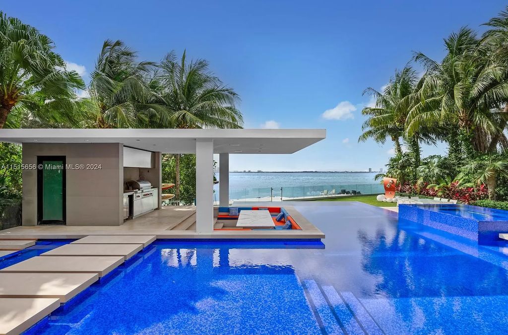 Welcome to 5004 N Bay Rd, a 2016 masterpiece by renowned designer Jennifer Post, blending modern architecture with timeless elegance. This 8-bed, 9-bath waterfront haven on prestigious North Bay Road boasts a stunning atrium courtyard, seamless living spaces, and a gourmet kitchen.