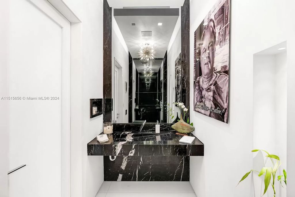 Welcome to 5004 N Bay Rd, a 2016 masterpiece by renowned designer Jennifer Post, blending modern architecture with timeless elegance. This 8-bed, 9-bath waterfront haven on prestigious North Bay Road boasts a stunning atrium courtyard, seamless living spaces, and a gourmet kitchen.
