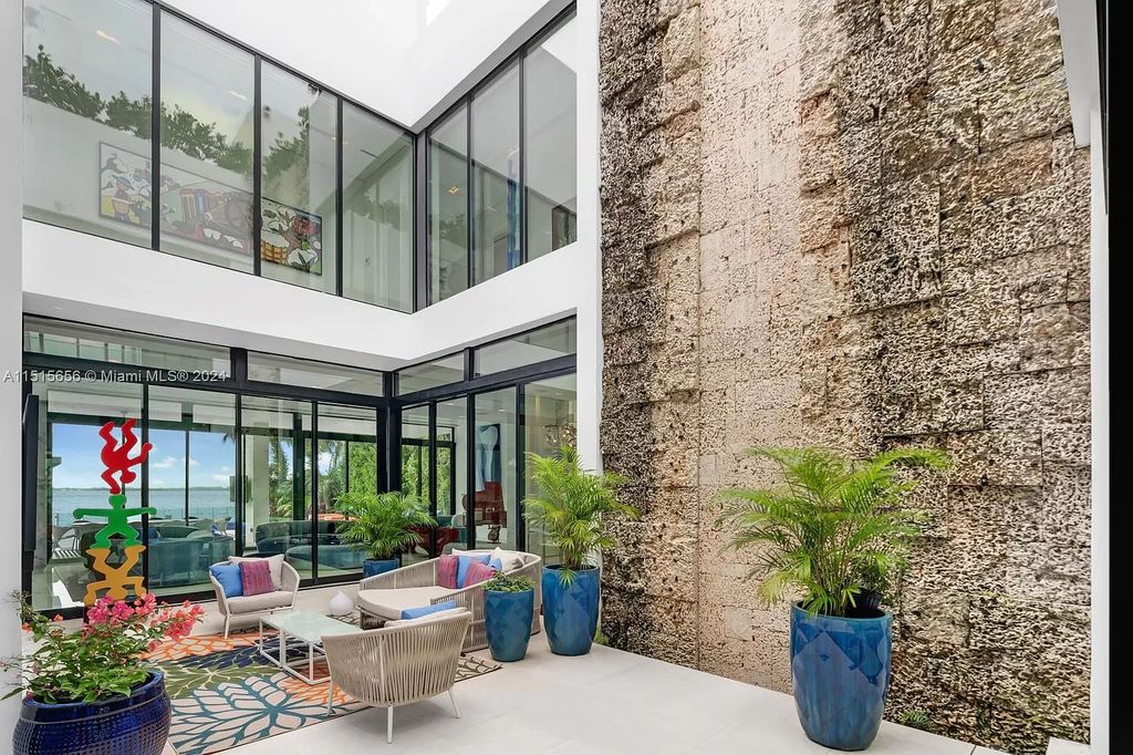 Welcome to 5004 N Bay Rd, a 2016 masterpiece by renowned designer Jennifer Post, blending modern architecture with timeless elegance. This 8-bed, 9-bath waterfront haven on prestigious North Bay Road boasts a stunning atrium courtyard, seamless living spaces, and a gourmet kitchen.