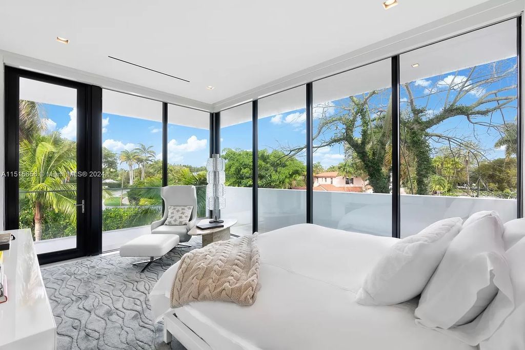 Welcome to 5004 N Bay Rd, a 2016 masterpiece by renowned designer Jennifer Post, blending modern architecture with timeless elegance. This 8-bed, 9-bath waterfront haven on prestigious North Bay Road boasts a stunning atrium courtyard, seamless living spaces, and a gourmet kitchen.