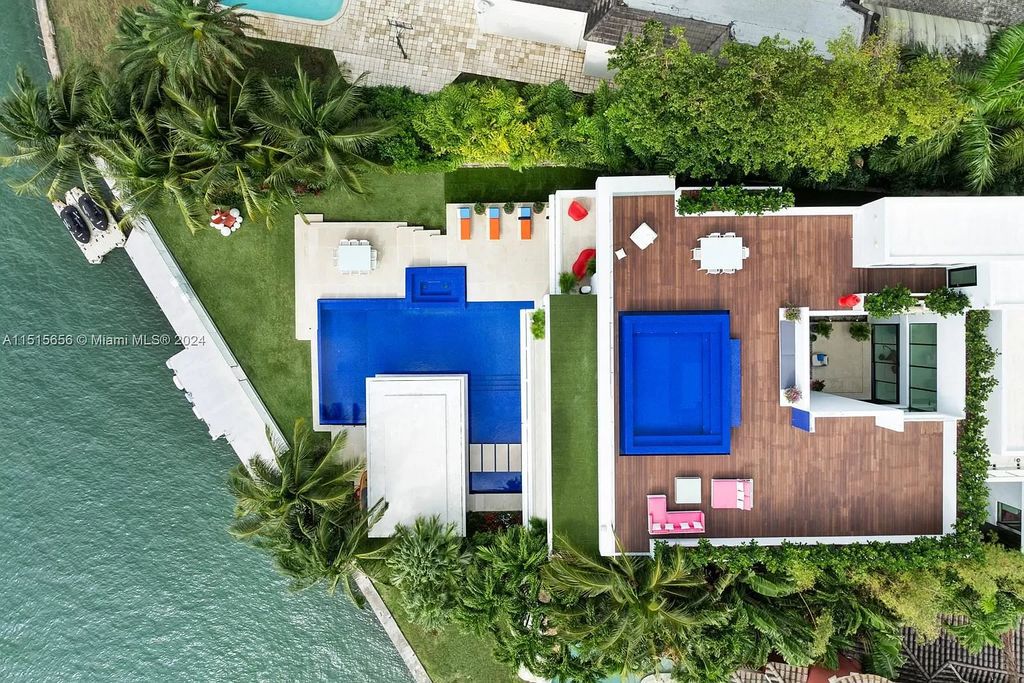 Welcome to 5004 N Bay Rd, a 2016 masterpiece by renowned designer Jennifer Post, blending modern architecture with timeless elegance. This 8-bed, 9-bath waterfront haven on prestigious North Bay Road boasts a stunning atrium courtyard, seamless living spaces, and a gourmet kitchen.