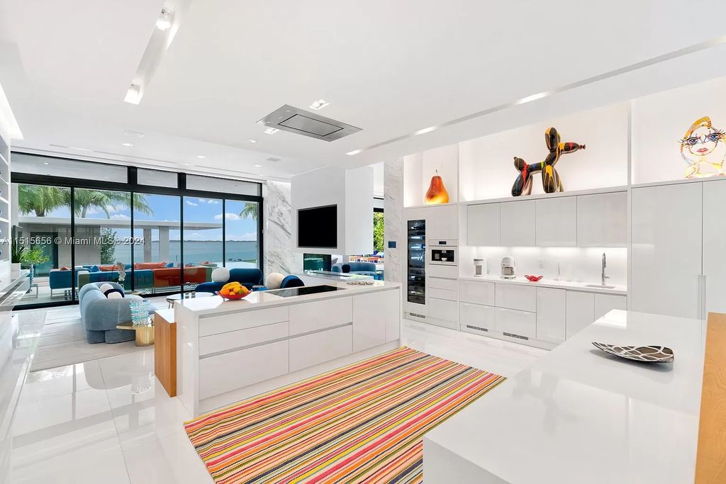 Welcome to 5004 N Bay Rd, a 2016 masterpiece by renowned designer Jennifer Post, blending modern architecture with timeless elegance. This 8-bed, 9-bath waterfront haven on prestigious North Bay Road boasts a stunning atrium courtyard, seamless living spaces, and a gourmet kitchen.