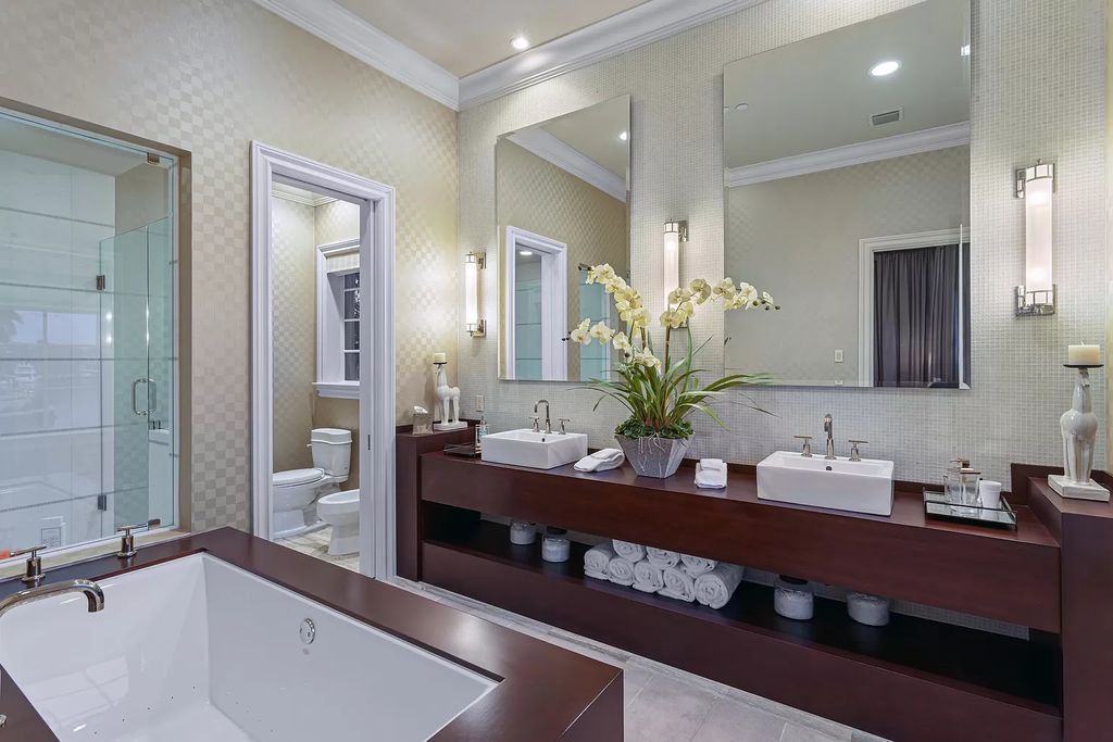Crafted by Frankel Estate Homes, designed by Carlos Martin Architects, and styled by Marc-Michaels, this 6-bedroom, 10-bathroom mansion showcases an elegant staircase, grand salon, modern kitchen, and a lavish primary suite with waterfront vistas.