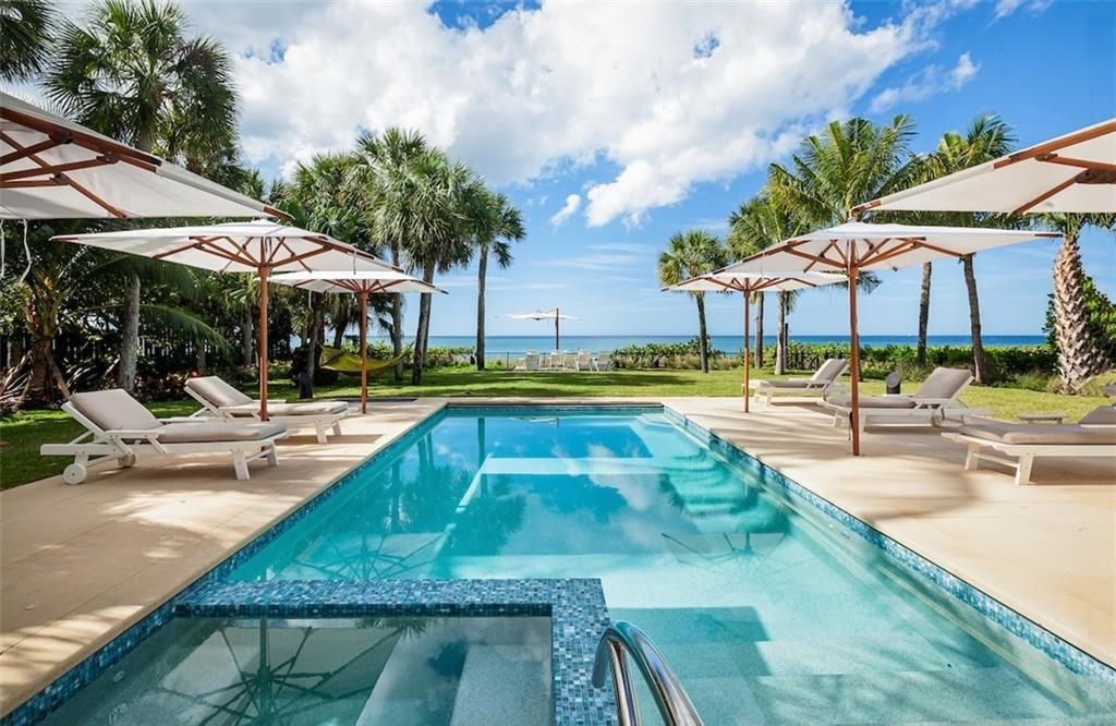 Nestled on nearly half an acre of prime beachfront land in Olde Naples, this exceptional home seamlessly blends coastal elegance with timeless craftsmanship.
