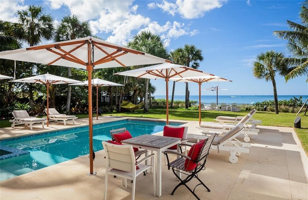 Nestled on nearly half an acre of prime beachfront land in Olde Naples, this exceptional home seamlessly blends coastal elegance with timeless craftsmanship.