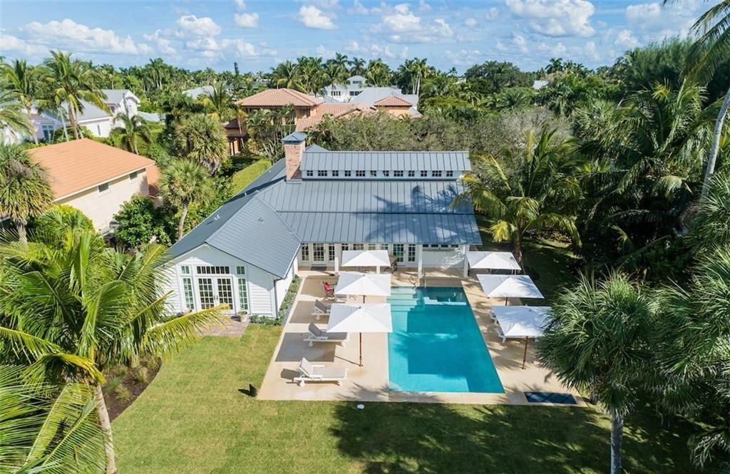 Nestled on nearly half an acre of prime beachfront land in Olde Naples, this exceptional home seamlessly blends coastal elegance with timeless craftsmanship.