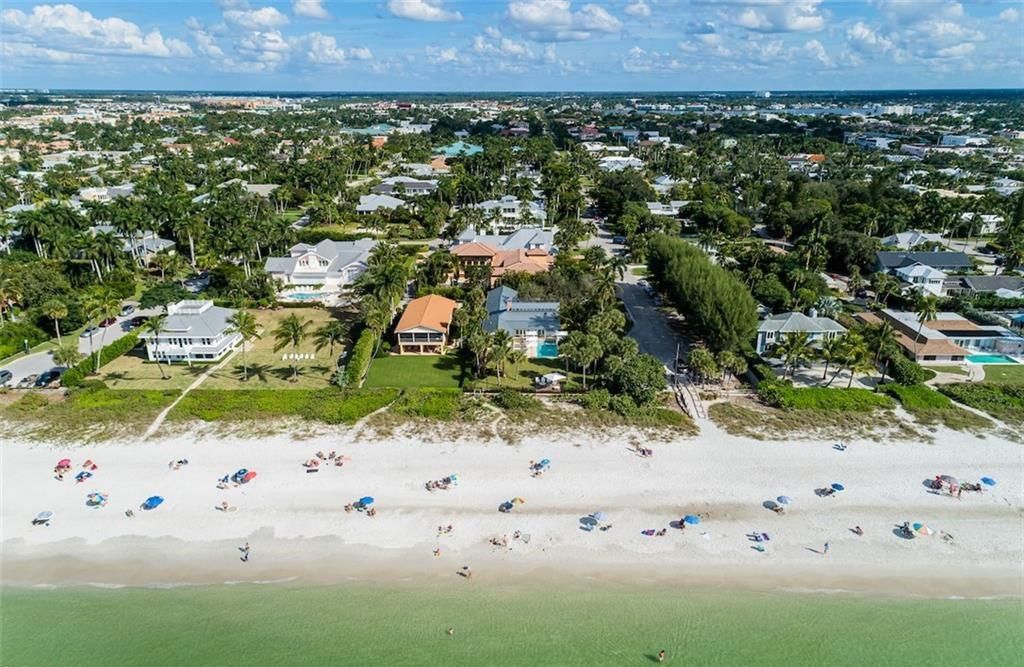 Nestled on nearly half an acre of prime beachfront land in Olde Naples, this exceptional home seamlessly blends coastal elegance with timeless craftsmanship.