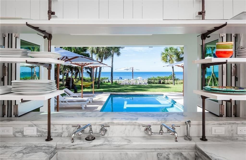 Nestled on nearly half an acre of prime beachfront land in Olde Naples, this exceptional home seamlessly blends coastal elegance with timeless craftsmanship.