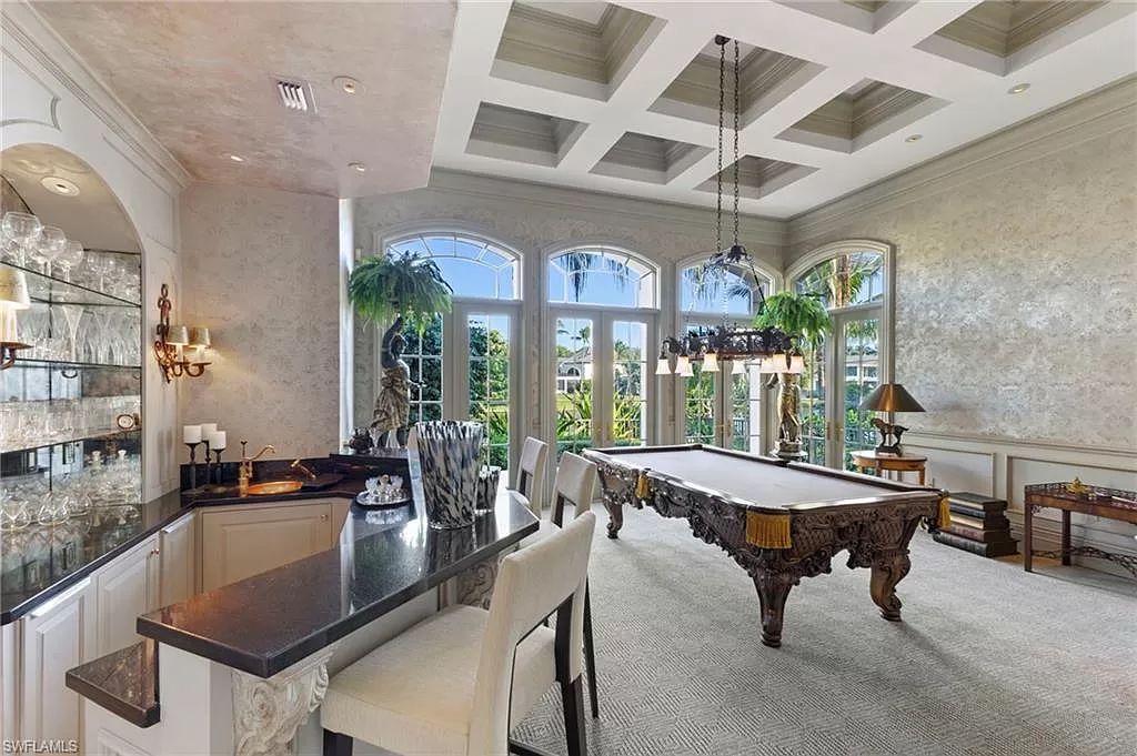 Welcome to the epitome of luxury living at 7310 Tilden Ln in Bay Colony Shores, Naples, Florida. This magnificent estate boasts over 10,000 square feet of meticulously crafted living space, featuring 6 palatial bedrooms with en-suite bathrooms, two additional half baths, and exquisite architectural details throughout.