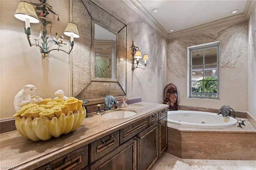 Welcome to the epitome of luxury living at 7310 Tilden Ln in Bay Colony Shores, Naples, Florida. This magnificent estate boasts over 10,000 square feet of meticulously crafted living space, featuring 6 palatial bedrooms with en-suite bathrooms, two additional half baths, and exquisite architectural details throughout.