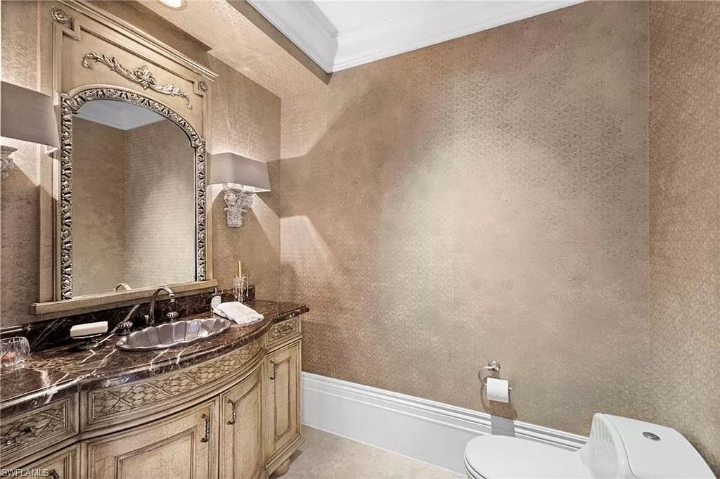 Welcome to the epitome of luxury living at 7310 Tilden Ln in Bay Colony Shores, Naples, Florida. This magnificent estate boasts over 10,000 square feet of meticulously crafted living space, featuring 6 palatial bedrooms with en-suite bathrooms, two additional half baths, and exquisite architectural details throughout.