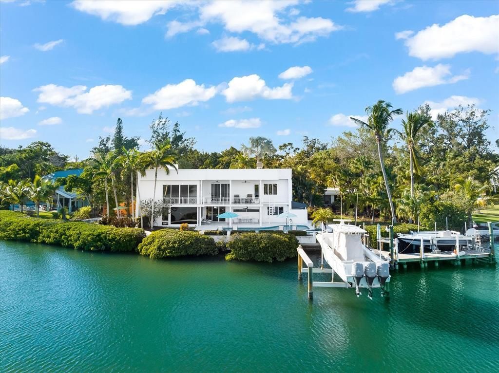 Nestled along the serene shores of Cocoanut Bayou, this captivating 4-bedroom, 4-bathroom sanctuary offers an unparalleled lifestyle for sailboat enthusiasts, boasting two boat lifts and panoramic water views.