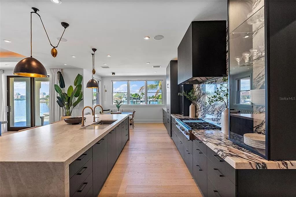 Indulge in the pinnacle of waterfront luxury living at 117 Bay Point Dr NE, Saint Petersburg, FL 33704. This exquisite property, nestled within the exclusive island enclave of Snell Isle, offers captivating ocean views from nearly every room, ensuring privacy and exclusivity among only 30 other houses.