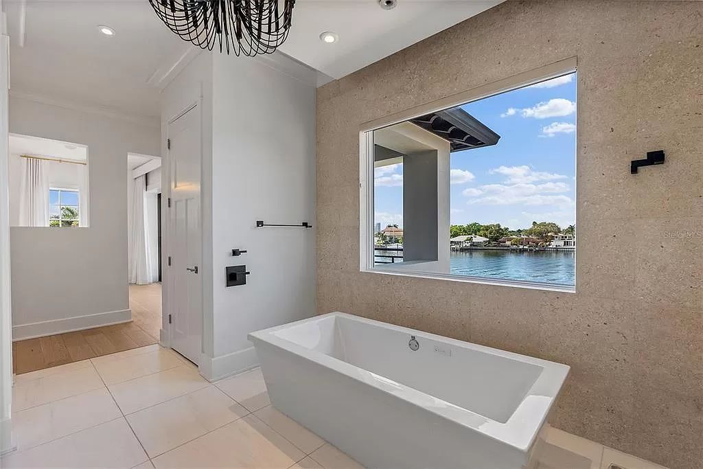 Indulge in the pinnacle of waterfront luxury living at 117 Bay Point Dr NE, Saint Petersburg, FL 33704. This exquisite property, nestled within the exclusive island enclave of Snell Isle, offers captivating ocean views from nearly every room, ensuring privacy and exclusivity among only 30 other houses.