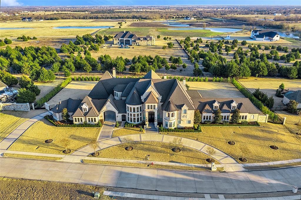 1252 Wales Drive Home in Rockwall, Texas. Step into luxury living at its finest with this illustrious estate set on over two private acres. Enjoy resort-style amenities including a pool with swim-up bar, fire features, waterfalls, and a covered patio with motorized screens.