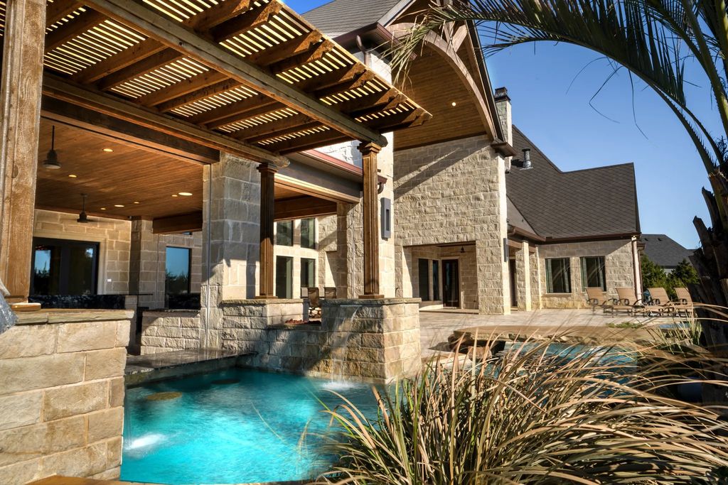 1252 Wales Drive Home in Rockwall, Texas. Step into luxury living at its finest with this illustrious estate set on over two private acres. Enjoy resort-style amenities including a pool with swim-up bar, fire features, waterfalls, and a covered patio with motorized screens.