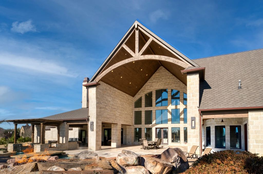 1252 Wales Drive Home in Rockwall, Texas. Step into luxury living at its finest with this illustrious estate set on over two private acres. Enjoy resort-style amenities including a pool with swim-up bar, fire features, waterfalls, and a covered patio with motorized screens.